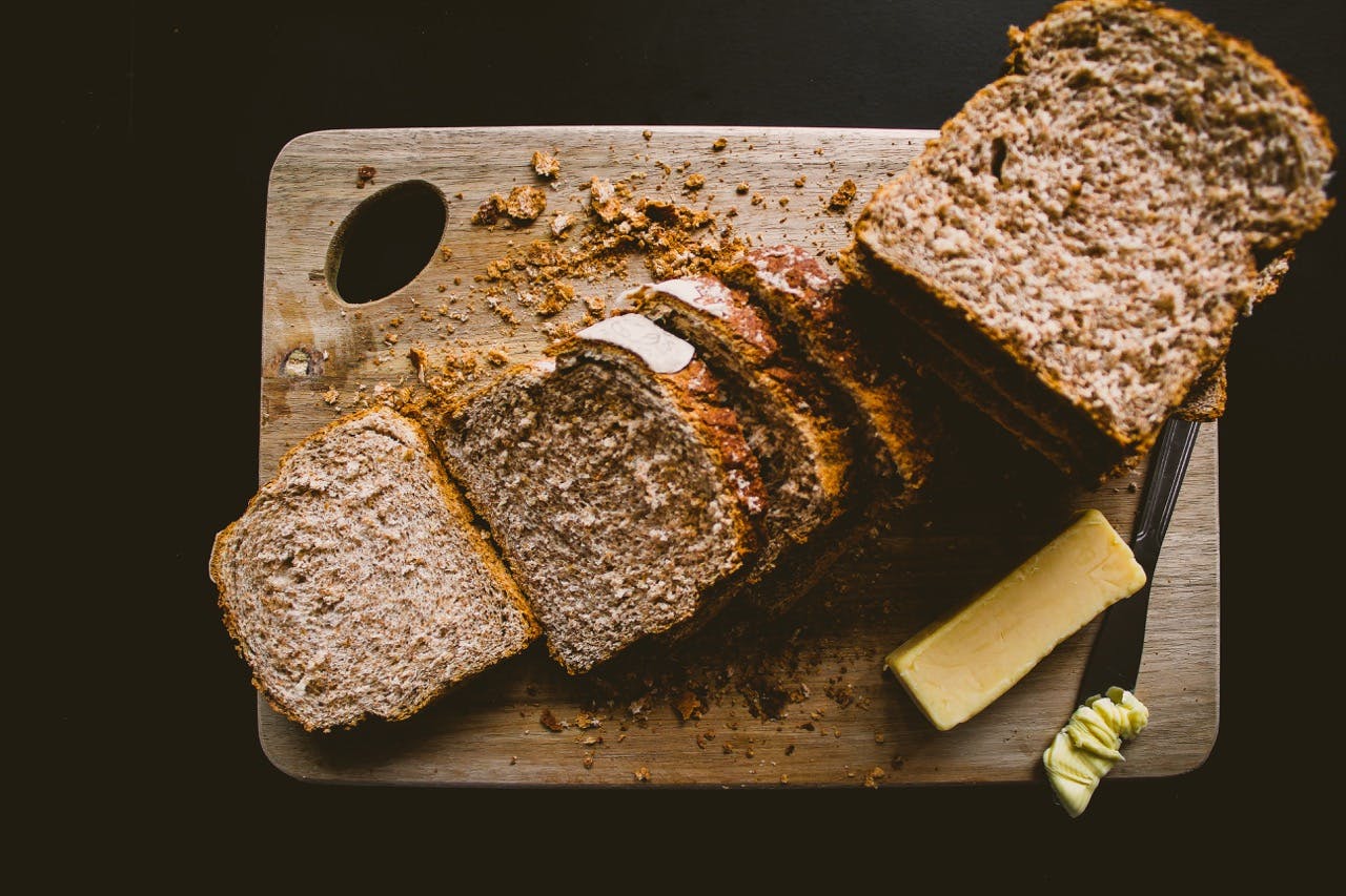 Kromki chleba, obok masło lub margaryna